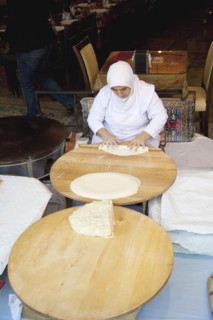 Turkey, Istanbul, Sultanahmet woman rolling out bread dough in restaurant. 
Photo : Stephen
