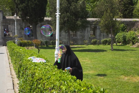 Turkey, Istanbul, Istanbul Sultanahmet woman selling bubble gun machine in park outside the Blue