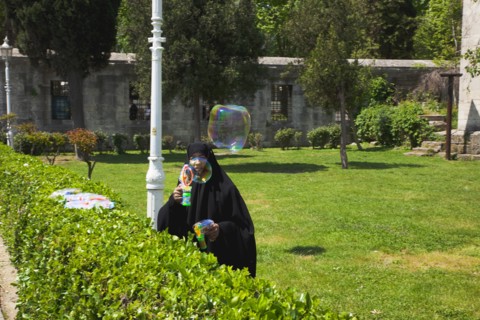 Turkey, Istanbul, Sultanahmet woman selling bubvble gun machine in park outside the Blue Mosque.