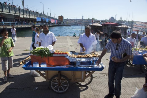 Turkey, Istanbul, Karakoy Galata fish market man selling freshly grilled fish served in a bread