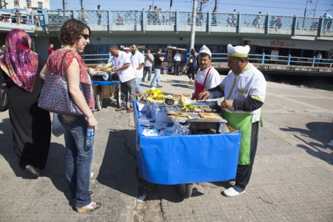 Turkey, Istanbul, Karakoy Galata fish market man selling freshly grilled fish served in a bread