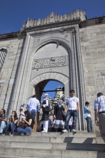 Turkey, Istanbul, Eminonu Yeni Camii New Mosque people on steps by the entrance. 
Photo : Stephen