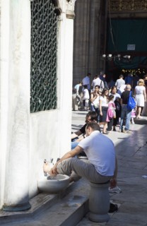 Turkey, Istanbul, Eminonu Yeni Camii New Mosque worshippers washing feet in courtyard. 
Photo :