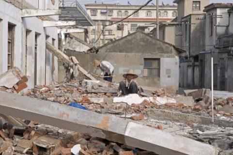 China, Jiangsu, Qidong, Female and male demolition workers in straw hats using hammers with
