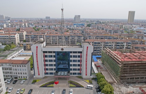 China, Jiangsu, Qidong, Bureau of Public Security with Chinese flag flying in forecourt and radio