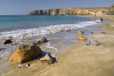 Ireland, County Waterford, Tramore, Kilfarrasy Beach and coastline with people riding horseback.