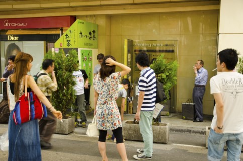Japan, Honshu, Tokyo, Ginza district smokers using designated street smoking area. 
Photo : Jon