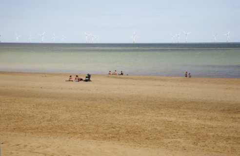 Wind Farm offshore on the horizon showing turbine blades.