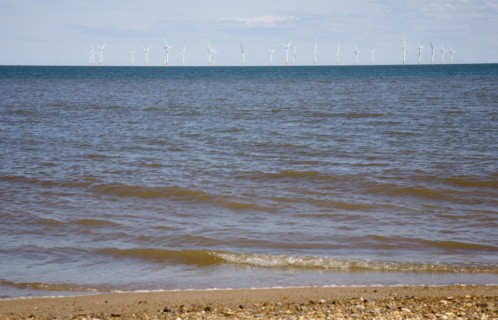 Wind Farm offshore on the horizon showing turbine blades.