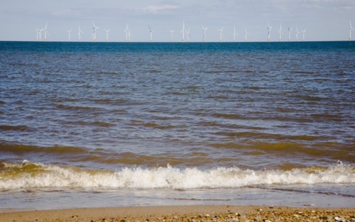Wind Farm offshore on the horizon showing turbine blades.
