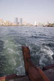 Abra water taxi view from rudder across the Creek with Twin Towers shopping mall and skyline behind.