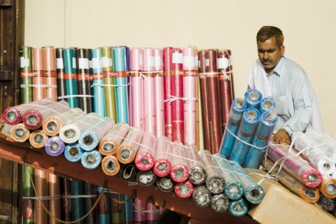 Expat from subcontinent loading colourful textiles at Souk on Bur Dubai side of the Creek.