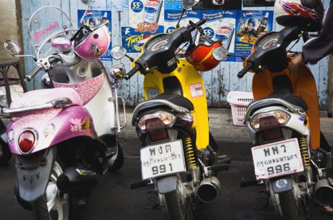 Brightly coloured motorcycle scooters and helmets.