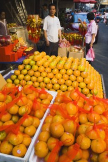 Stallholder attending oranges on stall for Chinese New Year.