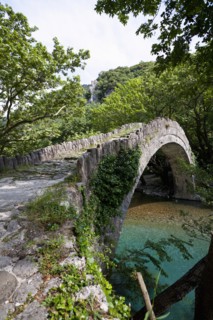 Old Greek traditional arch style stone bridge at a nature protected area with the cleanest rivers in Europe.
