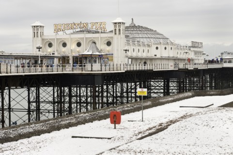Pier during winter with snow on the beach.