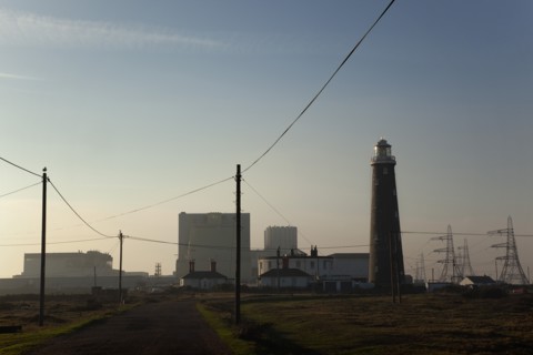 Silhouetted Nuclear power station and lighthouse.