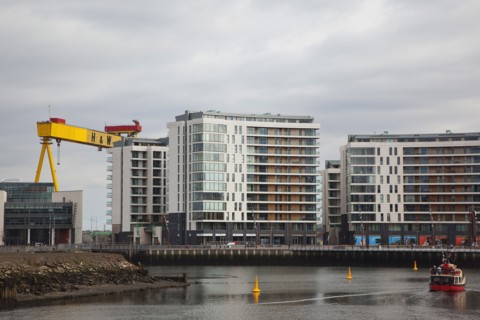 Titanic Quarter Modern apartment blocks on the site of the Harland & Wolff shipyard with sightseeing cruise boat.