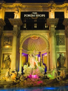 The Strip Caesars Palace Forum Shops exterior illuminated at night.