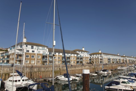 View over boats moored in the Marina with apartment buildings behind.