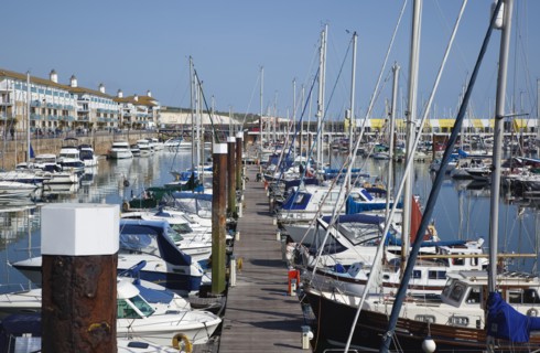 View over boats moored in the Marina with apartment buildings behind.