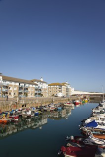 View over boats moored in the Marina with apartment buildings behind.