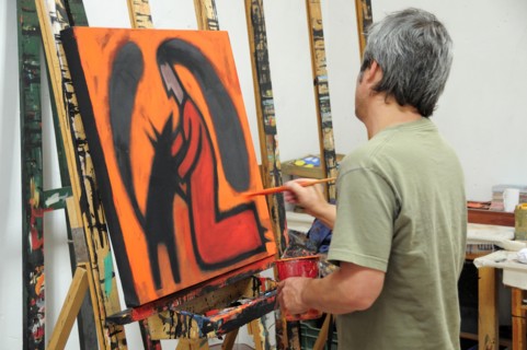 Mexico, Bajio, San Miguel de Allende, Artist Juan Ezcurdia in his studio working on painting at