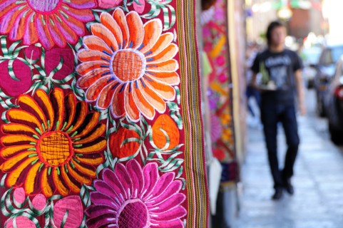 Mexico, Bajio, San Miguel de Allende, Brightly coloured embroidered textile hanging outside arts