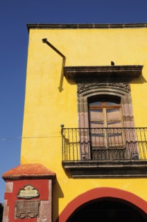 Mexico, Bajio, San Miguel de Allende, El Jardin Part view of yellow painted exterior facade of