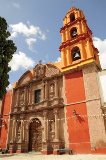 Mexico, Bajio, San Miguel de Allende, Exterior facade and bell tower of orange and yellow painted