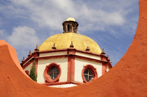 Mexico, Bajio, San Miguel de Allende, Dome of the Parroquia church part framed by orange painted