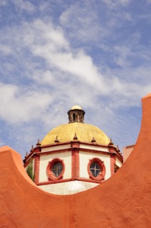 Mexico, Bajio, San Miguel de Allende, Dome of the Parroquia church part framed by orange painted