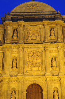 Mexico, Oaxaca, Part view of baroque exterior facade of cathedral at night with relief carving of