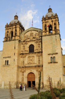 Mexico, Oaxaca, Church of Santo Domingo exterior facade and bell towers with small group of people