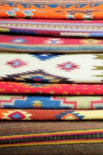 Mexico, Oaxaca, Detail of stacked weavings and carpets by Tomas and Arnulfo Mendoza. Photo : Nick