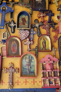 Mexico, Michoacan, Patzcuaro, Religious kitsch art displayed on yellow painted wall. Photo : Nick