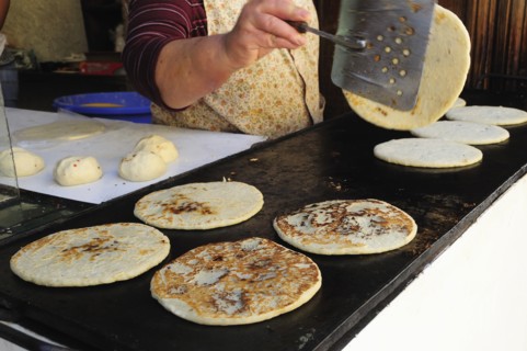 Mexico, Bajio, San Miguel de Allende, Cropped shot of woman making tortillas turning them as they