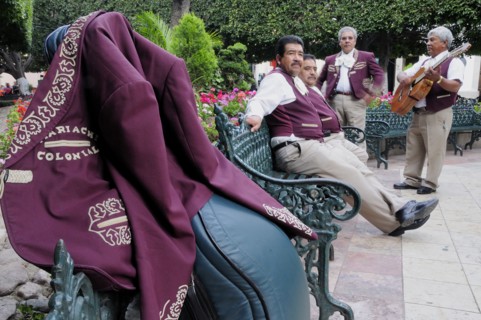 Mexico, Bajio, Guanajuato, Jardin de la Union Mariachi group taking a rest from playing purple