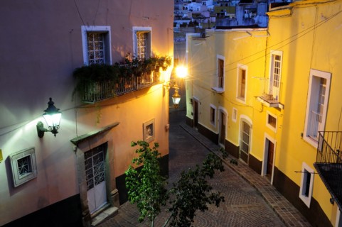 Mexico, Bajio, Guanajuato, Elevated view over street corner at night with painted building facades