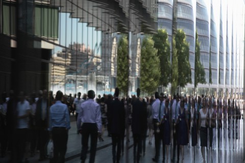 England, London, Southwark Office workers reflected in glass building next to City Hall. Photo :