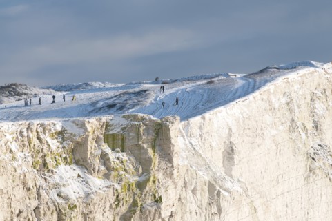 England, East Sussex, Seaford Head, Snow on cliffs with people toboganing. Photo : Bob Battersby