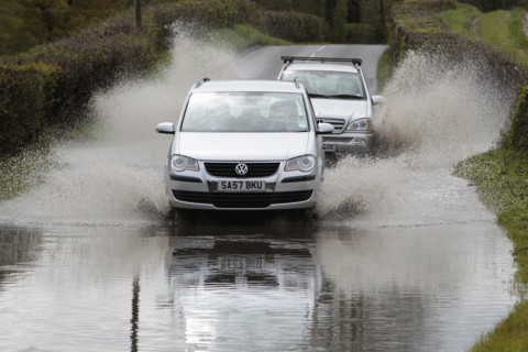 England, Kent, Flooding, Flooded country road with cars driving slowly through waters. Photo : Sean