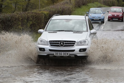 England, Kent, Flooding, Flooded country road with cars driving slowly through waters. Photo : Sean
