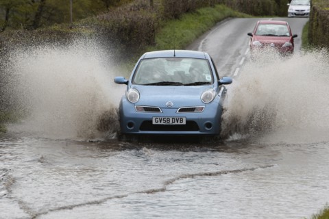England, Kent, Flooding, Flooded country road with cars driving slowly through waters. Photo : Sean