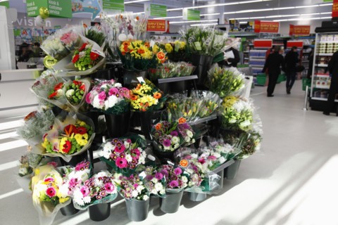 England, Shopping, Supermarket, Bunches of fresh flowers for sale by entrance. Photo : Sean Aidan