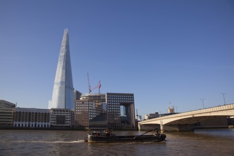 England, London, Southwark southbank Barge passing under London Bridge with the Shard skyscraper