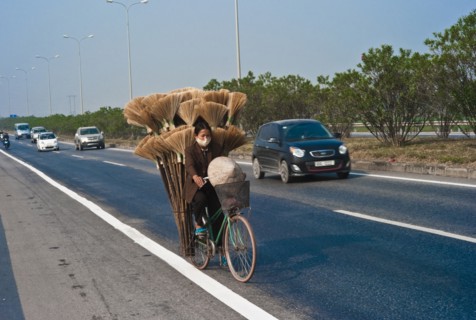 Vietnam, Transport, Woman on Bicycle in north region with a load of brooms. 
Photo Richard Rickard