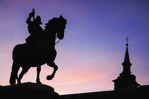 Spain, Madrid, Statue of King Philip II in Plaza Mayor silhouetted against evening sky. 
Photo