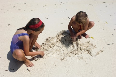 Zanzibar, Paje, Two young girls playing in the hot sunshine of the sandy beach. 
Photo Nic I Anson