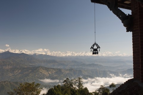 Nepal, Nagarkot, View across clouded valley towards Himalayan mountains wind chime hanging from